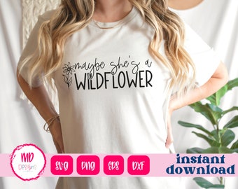 May include: A white t-shirt with the text "maybe she's a wildflower" in black lettering. A small flower graphic is above the text.