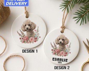 May include: Two white ceramic poodle ornaments with floral designs. Design 1 is labelled "DESIGN 1". Design 2 features the name "Charlie" and the year "2025". Each has a jute string for hanging. The image also includes a "FAST DELIVERY" sticker.