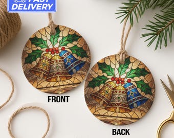 Puede incluir: Adorno navideño redondo con un diseño de campanas de vidrieras. El adorno presenta tres campanas en oro y azul, rodeadas de hojas verdes de acebo y bayas rojas. Se ven el anverso y el reverso del adorno.