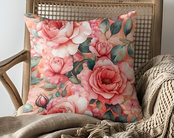 May include: A throw pillow with a floral pattern featuring pink roses and green leaves on a peach background.