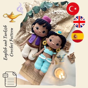 Pode incluir: Bonecas de crochê de Aladdin e Jasmine, com roupas detalhadas em roxo, azul e branco. O texto "English and Turkish Crochet Pattern" é visível. Há também uma ilustração de uma lâmpada dourada.