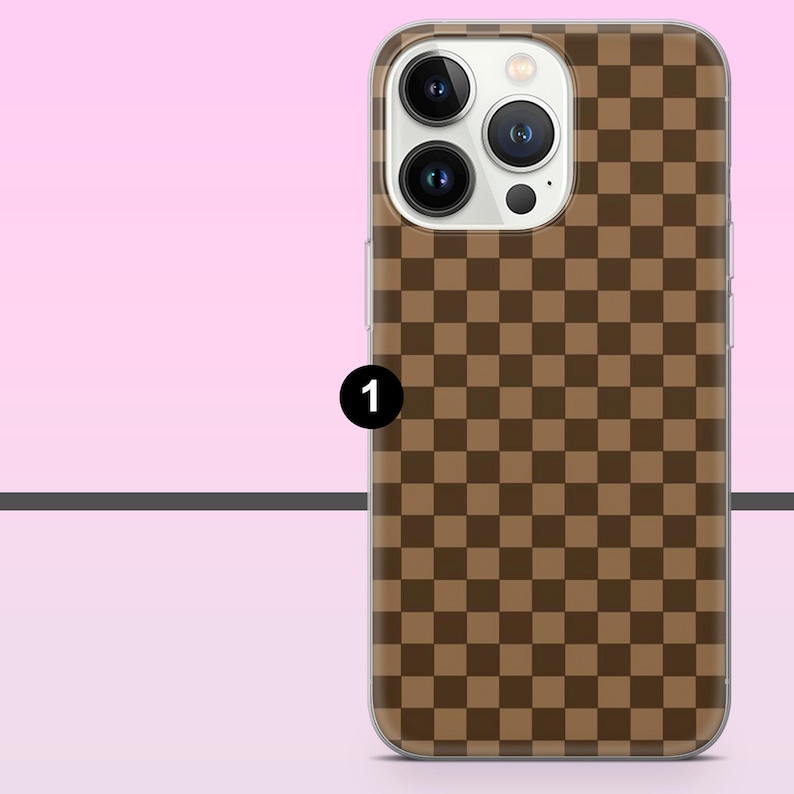 May include: A brown and tan checkered phone case. The case has a clear border and a camera cutout. The design is a repeating pattern of squares in two shades of brown. The phone case is shown against a pink background.