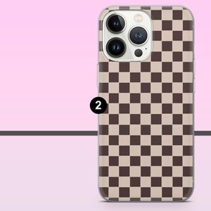 May include: A phone case with a brown and beige checkerboard pattern. The case has a clear border and features the camera lenses and flash of the phone. The number "2" is printed on the case.