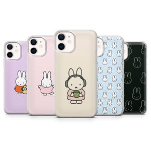 Op de afbeelding: Een verzameling telefoonhoesjes met het stripfiguur Miffy. De hoesjes zijn in verschillende kleuren, waaronder lavendel, roze, beige, lichtblauw en zwart. Elk hoesje heeft een ander Miffy-ontwerp, sommige met accessoires.