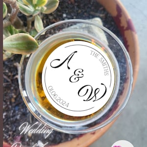 May include: White round drink topper with black text that says "The Smiths" and "A & D" with the date "01.06.2024" below. The topper is on top of a glass of beer. The text "Wedding Drink Toppers" is written in cursive below the glass.