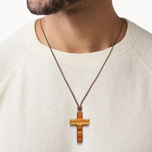 Olive Wood Cross Necklace, Handcrafted in Nazareth. Minimalist Pendant. Christian necklace on man model background.