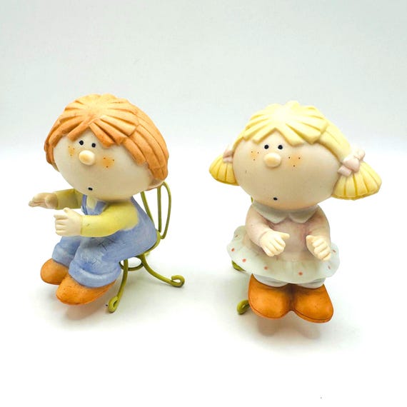 Vintage Bumpkin Like Figurines Perched on Rustic Metal Chairs