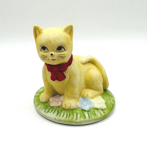 Decorative porcelain cat figurine with a red bow
