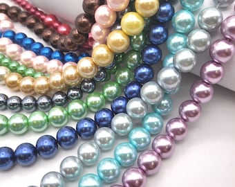 May include: A collection of beaded necklaces in various colors, including pink, brown, blue, green, yellow, and purple. The beads are round and have a glossy finish, suggesting they are made of glass or a similar material. The necklaces are arranged in a diagonal pattern.
