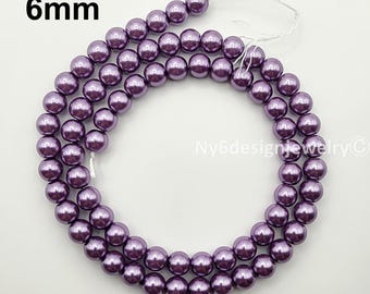 May include: Strands of 6mm purple beads. The beads are a deep, lustrous purple color and are strung together on a white string. The beads are arranged in a circular pattern. The text "6mm" is in the upper left corner.