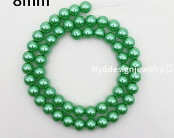 May include: A strand of 8mm green beads. The beads are a light, glossy green color and are strung together to form a circular shape. The text "8mm" is in the upper left corner.