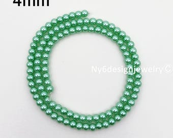 May include: A strand of 4mm light green beads, arranged in a circular pattern. The beads are a consistent size and color, with a glossy finish. The text "4mm" is in the upper left corner. The text "Ny6designjewelry" is in the lower right corner.
