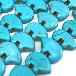 May include: Turquoise blue heart-shaped beads with a hole in the center. The beads have a mottled, marbled appearance.