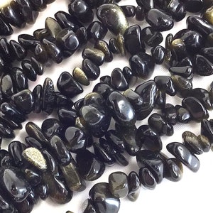 May include: A strand of black obsidian gemstone chips, with some chips showing a golden sheen.