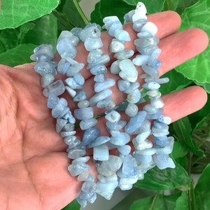 May include: A set of five aquamarine chip bracelets. The bracelets are made of light blue, translucent chips of aquamarine, strung together on elastic.