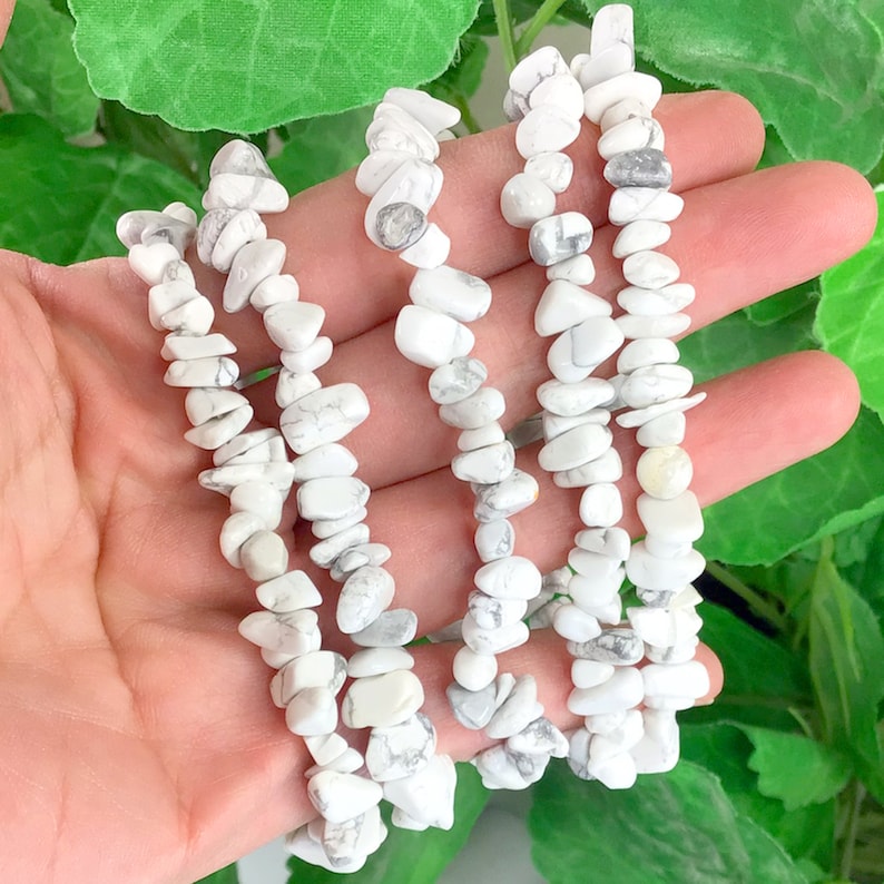 May include: A strand of white howlite chip beads. The beads are irregular in shape and have a natural, polished finish.