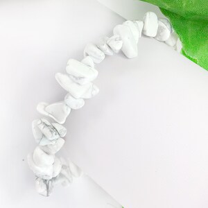 May include: White howlite chip bracelet. The bracelet is made of small, irregular shaped white stones with gray veining.