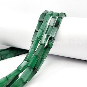 May include: Strands of green rectangular beads. The beads have a polished finish and are strung together. The beads are a deep, rich green color. The background is white.