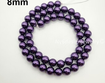 May include: A strand of 8mm dark purple beads. The beads are round and have a glossy finish. The beads are strung together with a white string. The text "8mm" is in the upper left corner.