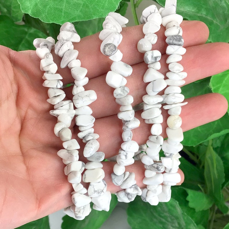 May include: Four strands of white howlite chip bead bracelets. The beads are irregular in shape and have a white and gray marbled pattern.