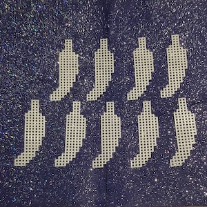 May include: Eight white plastic chili pepper ornaments with a grid pattern. The ornaments are arranged in two rows of four on a sparkly blue background.