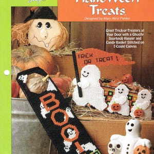Könnte beinhalten: Ein Halloween-Nadelarbeitsmuster mit einem schwarzen Türknaufaufhänger mit der Aufschrift "BOO" und Geisterfiguren. Das Bild zeigt auch einen Geist, der eine "Trick or Treat"-Flagge hält, sowie weitere Halloween-Dekorationen.