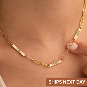 May include: A gold-colored chain necklace with rectangular nameplates. The nameplates are engraved with the names "EMMA", "CLAIRE", and "JACK". The necklace is worn around the neck. The image also includes the text "SHIPS NEXT DAY".