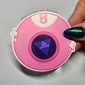 May include: Pink 8-ball sticker with a blue triangle and the text "Oil Your Cuticles".