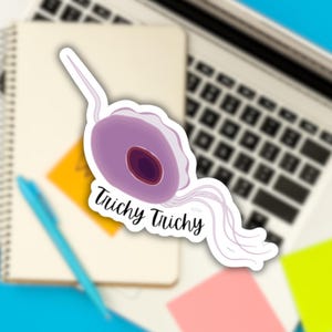 May include: A sticker featuring a purple and pink cell with a long tail and the text "Trichy Trichy".