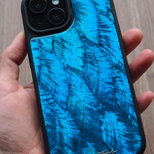 Puede incluir: Una funda para teléfono azul y negro con un diseño marmoleado único. La funda tiene una protuberancia de cámara elevada y un borde negro.