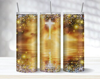 May include: A set of three stainless steel tumblers with a wraparound design featuring a cross, set against a golden, ethereal landscape with sparkling accents. Each tumbler includes a straw.