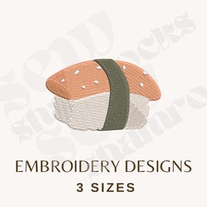 May include: An embroidered sushi design with a salmon-coloured topping with white accents, a green seaweed band, and a white rice base. The text "EMBROIDERY DESIGNS" and "3 SIZES" are below the sushi illustration.