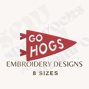 Può includere: Un disegno per ricamo a forma di gagliardetto triangolare rosso con il testo bianco GO HOGS. Sotto il gagliardetto, il testo recita EMBROIDERY DESIGNS e 8 SIZES. Il disegno presenta un motivo a punti strutturato sul gagliardetto rosso.