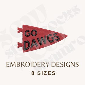 May include: A red triangular pennant embroidery design featuring the black stitched text GO DAWGS. The design includes two small red tabs on the left side. Below the pennant, the text reads EMBROIDERY DESIGNS and 8 SIZES in dark brown.