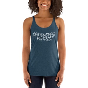 May include: A dark blue tank top with the text "CONQUEROR MINDSET" in white lettering.