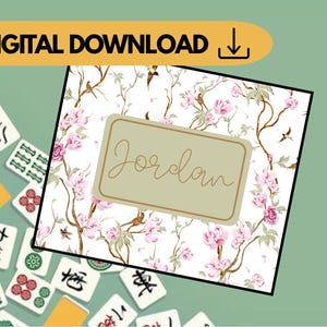Può includere: Download digitale con un motivo floreale di fiori rosa, rami marroni e uccelli. Un rettangolo beige chiaro con il nome "Jordan" in corsivo è centrato. Tessere di Mahjong sparse.