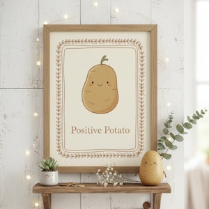 Puede incluir: Un marco con una ilustración de patata de dibujos animados y las palabras "Positive Potato". La impresión se muestra en una estantería de madera con una pequeña suculenta, una figura de patata y una etiqueta que dice "Handmade with Love!"