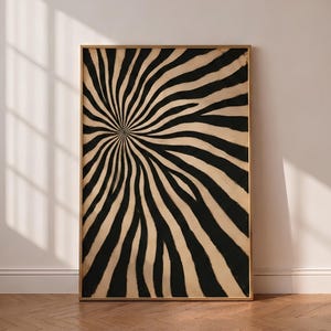 May include: A rectangular wall art print in a thin gold frame featuring a high-contrast graphic pattern of black and beige wavy lines that radiate outward from a central point, creating a dynamic, swirling, and hypnotic optical effect.