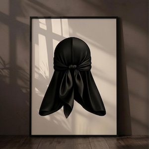 Può includere: Una stampa artistica da parete incorniciata che presenta un'illustrazione centrata di un durag nero annodato sul retro. Il durag ha una consistenza liscia e satinata con pieghe e drappeggi visibili, su uno sfondo beige chiaro uniforme.