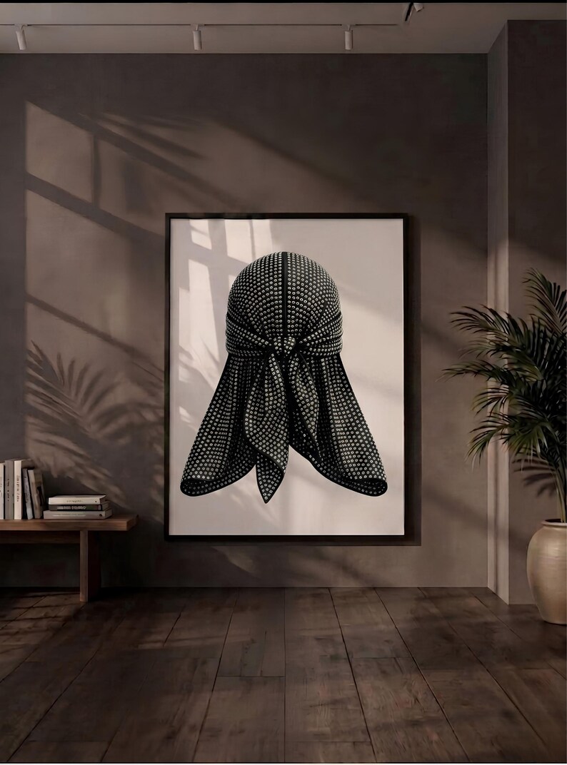 May include: A framed wall art print featuring a black durag covered in small, reflective silver studs. The durag is depicted with a central knot and two hanging ties, set against a plain white background within a thin black frame.