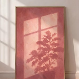 Peut inclure: Une impression d'art murale rectangulaire encadrée présentant une palette de couleurs rose poussiéreux et terre cuite monochrome. L'œuvre représente la silhouette d'une plante en pot projetée sur un mur par la lumière d'une fenêtre à croisillons.