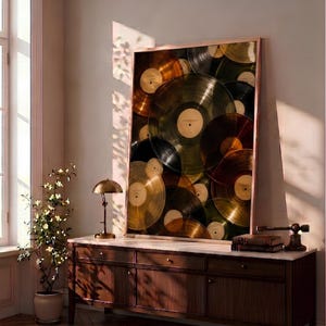 May include: A large rectangular framed wall art piece featuring a layered collage of translucent vinyl records in shades of gold, amber, and dark brown, displayed in a thin metallic frame with a light-colored center label on each record.