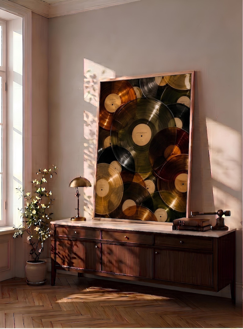 May include: A large rectangular framed wall art piece featuring a layered collage of translucent vinyl records in shades of gold, amber, and dark brown, displayed in a thin metallic frame with a light-colored center label on each record.