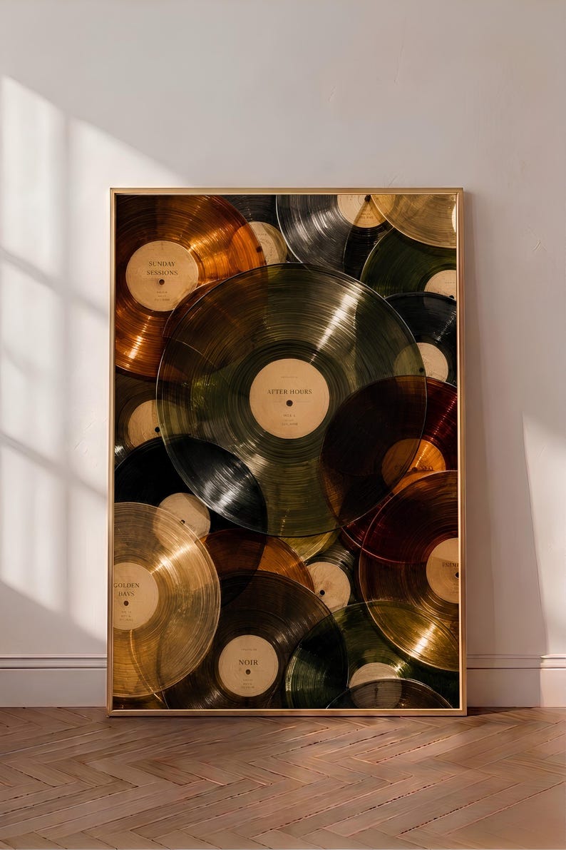 May include: A framed vertical wall art print featuring a collage of overlapping translucent vinyl records in various colors including amber, olive green, black, and gold. Each record has a central label with text such as Sunday Sessions, After Hours, Golden Days, and Noir.