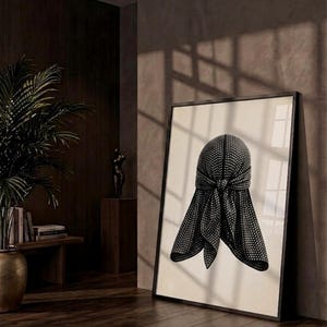 May include: A framed wall art print featuring a black durag with a white polka dot pattern. The durag is depicted with a central knot and two hanging ties, centered on a light cream background within a thin black frame.