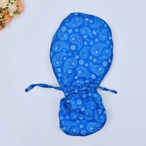 Puede incluir: Una bolsa de tela azul con un patrón paisley blanco. La bolsa tiene un cierre de cordón.