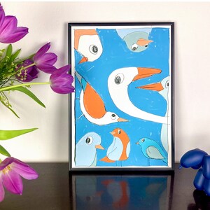 May include: A framed illustration of colorful birds with white and orange beaks on a blue background.