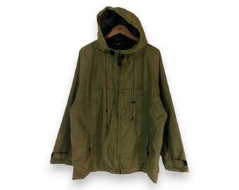 May include: Olive green hooded jacket with a full zipper closure and two front pockets. The jacket features a drawstring hood and black drawstrings. The cuffs have black accents. The jacket is made of a lightweight material.