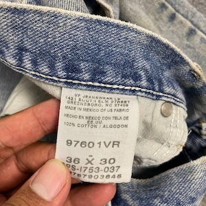 K&ouml;nnte beinhalten: Nahaufnahme eines hellblauen Jeans-Etiketts. Das Etikett lautet "VF JEANSWEAR LP" und enth&auml;lt die Gr&ouml;&szlig;e "36 x 30". Die Jeans besteht aus 100% Baumwolle.
