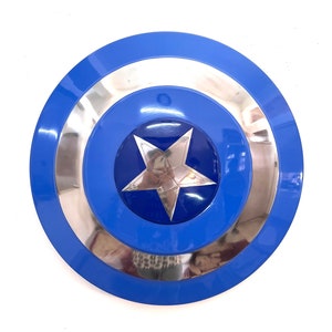 Puede incluir: Un escudo redondo azul y plateado con una estrella plateada central. El escudo tiene un acabado brillante y un dise&ntilde;o en capas, con un anillo exterior azul, un anillo central plateado y un centro azul. Una estrella de cinco puntas est&aacute; en el centro.